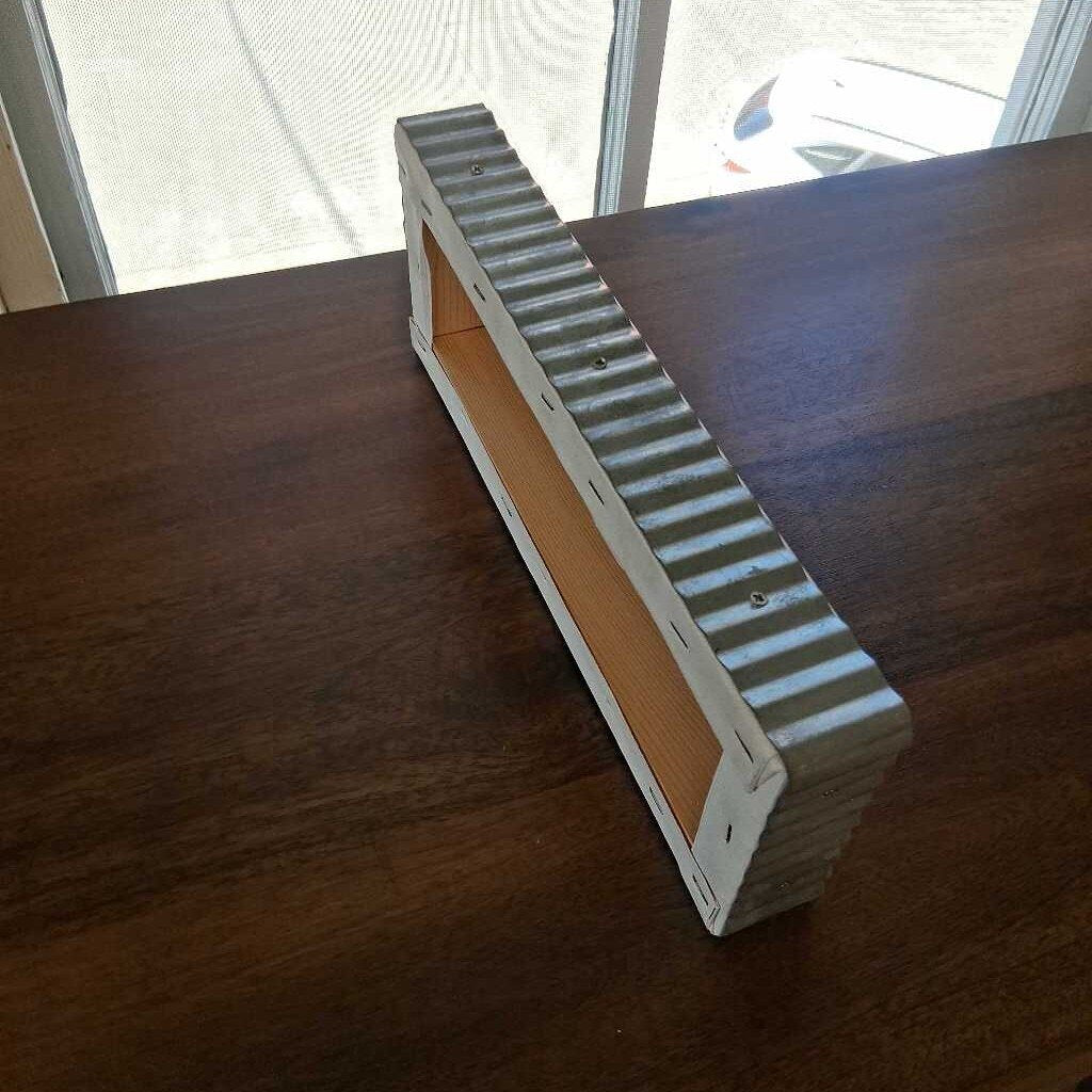 Metallic step or ramp on a wooden surface with a window in the background