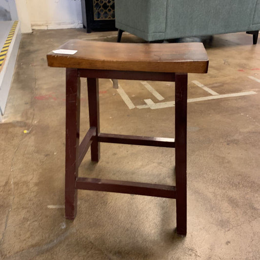 Wooden stool on a concrete floor with a blurred background