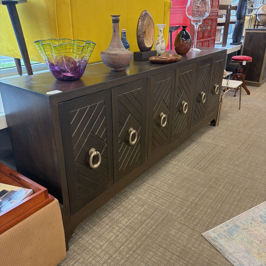 Dark wooden sideboard with decorative items on top in a store setting