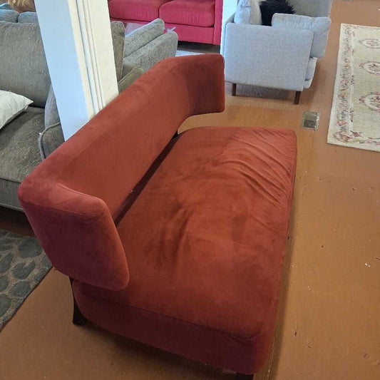 Red sofa in a living room with other furniture and decor.