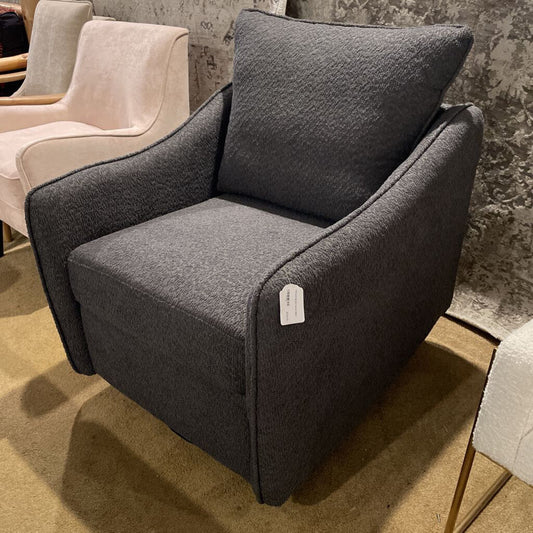 A modern charcoal grey swivel armchair upholstered in a nubby bouclé-style fabric, featuring a high back and integrated sloped armrests.