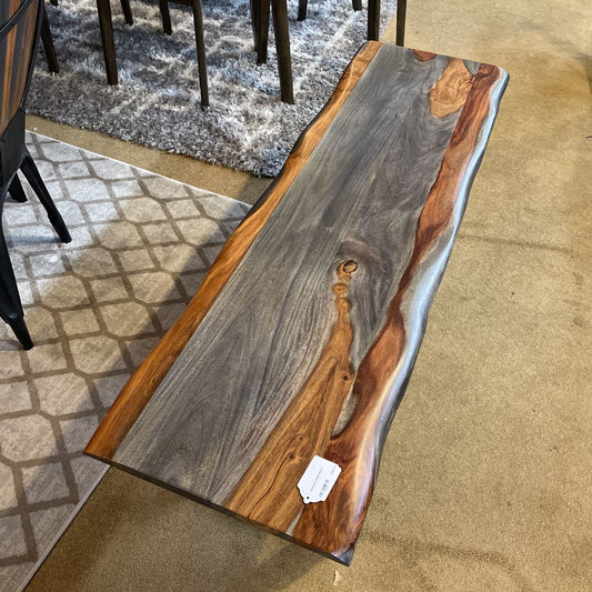 Wooden dining table with a gray and brown finish on a carpeted floor.