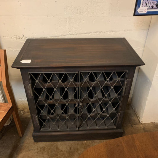 Wooden wine rack with lattice design against a white wall.