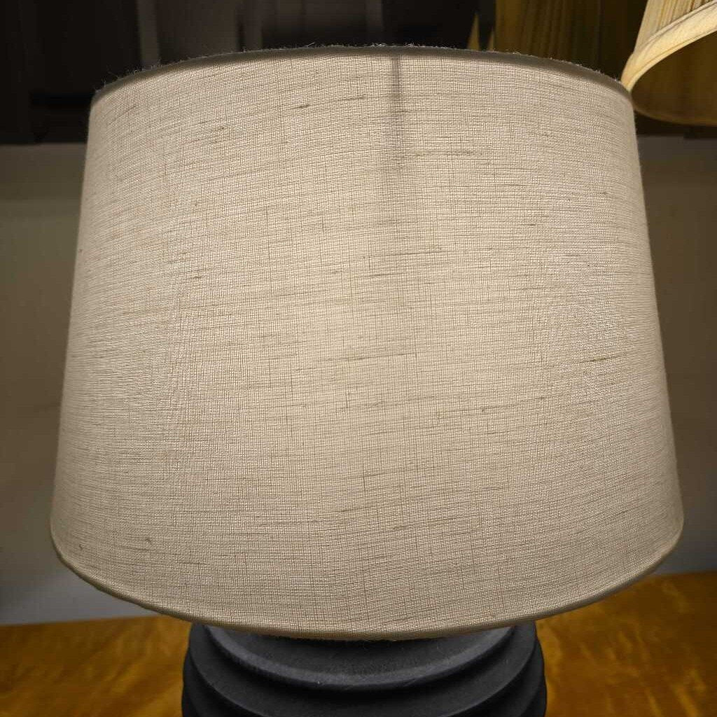 Textured beige lampshade on a wooden surface