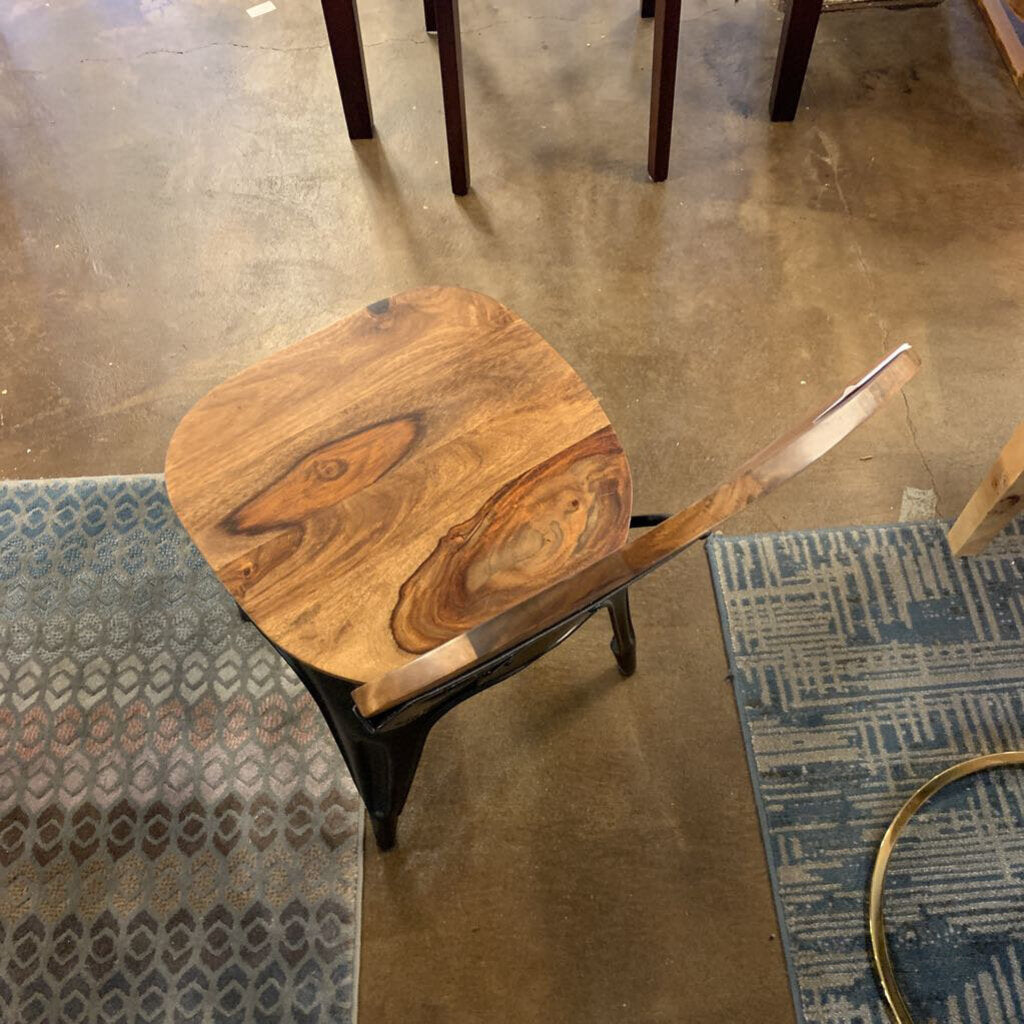 Wooden stool with a unique grain pattern on a concrete floor.