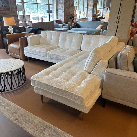 Beige sectional sofa in a living room setting with decor elements.