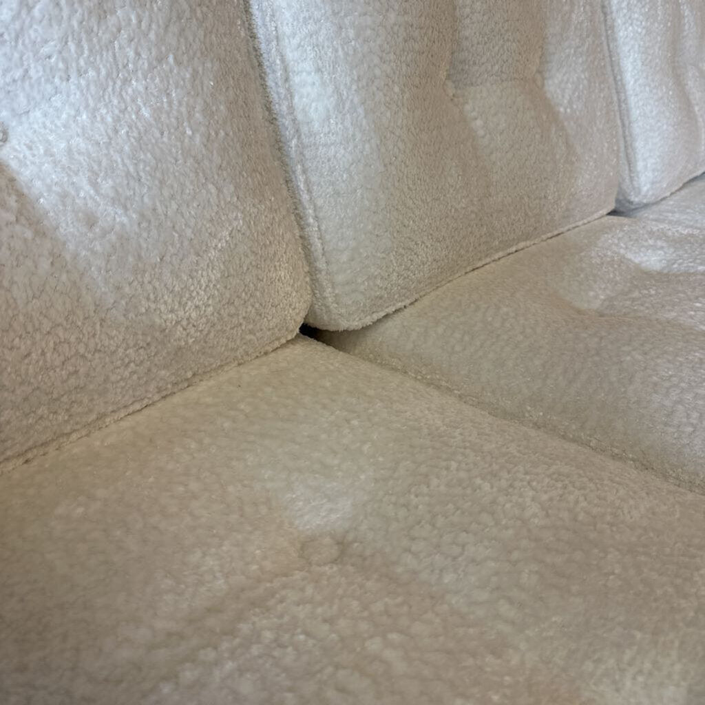 Close-up of beige textured fabric, possibly a sofa or cushion