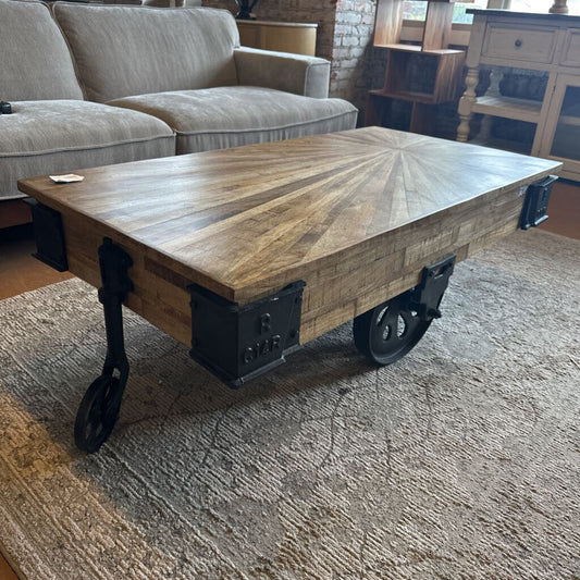 Wooden coffee table with industrial design on a carpeted floor