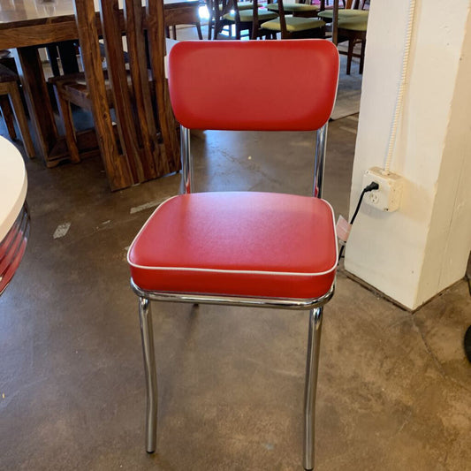 Red chair with metal legs in a room with tables and chairs