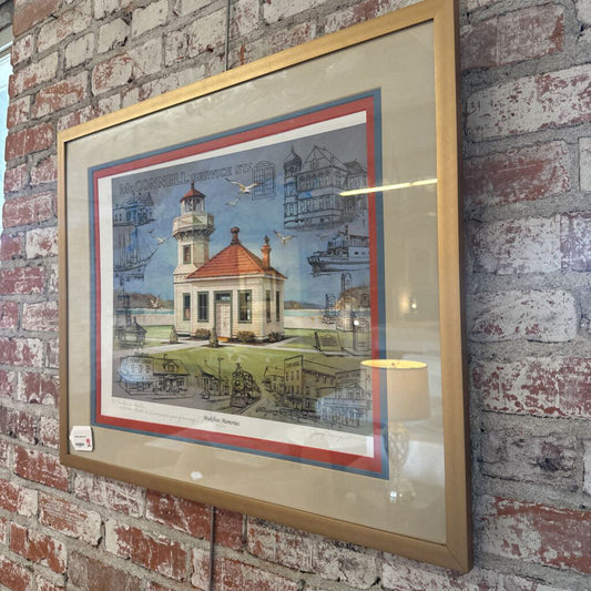 Framed artwork of a lighthouse on a brick wall