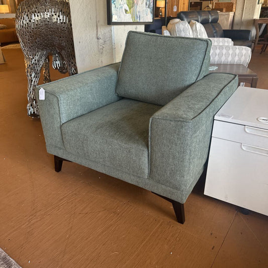 Green armchair in a room with furniture and decor