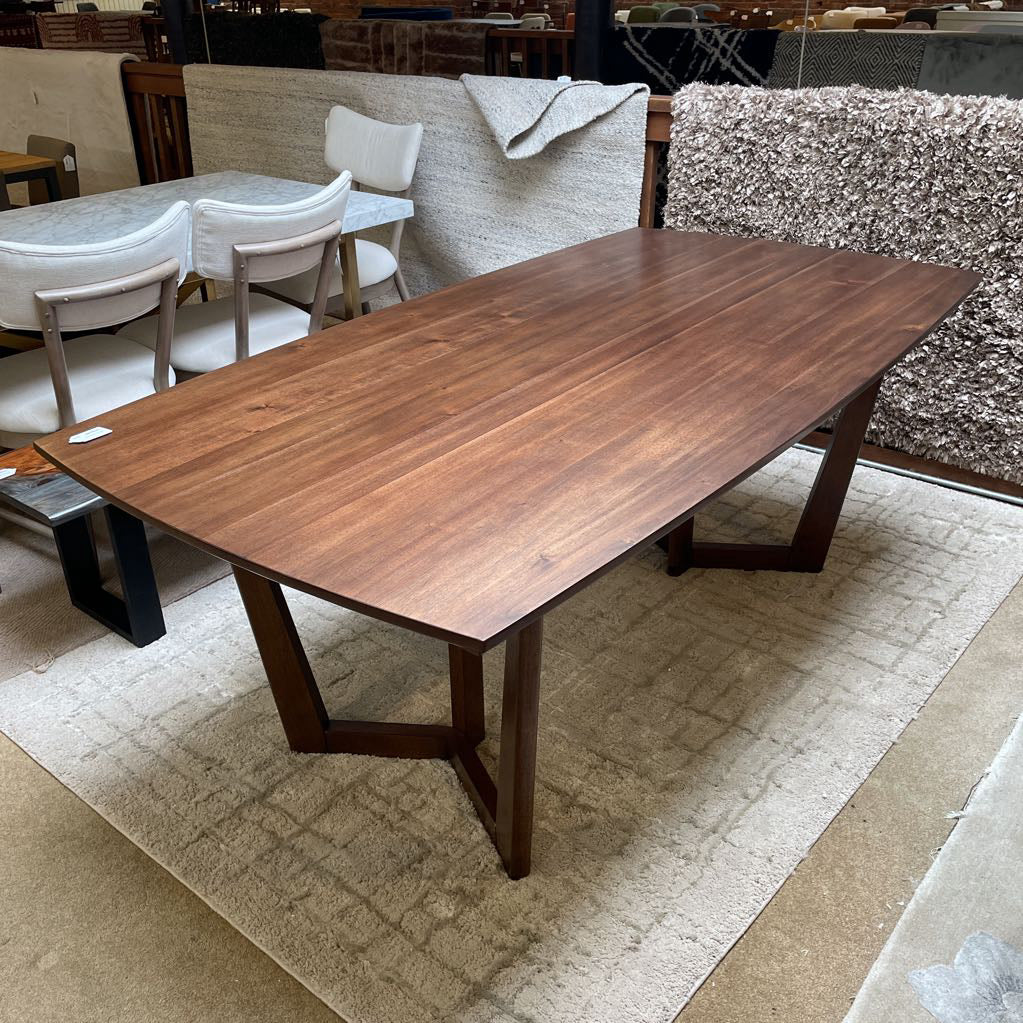 Wooden dining table with chairs in a storage or warehouse setting