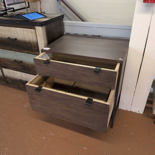 Wooden dresser with open drawers on a brown floor.
