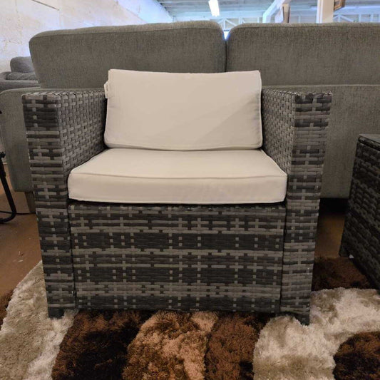 Wicker chair with beige cushion in a showroom setting