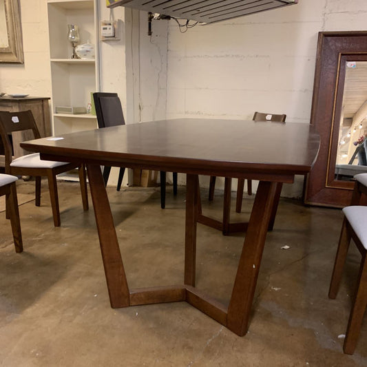 Wooden dining table with chairs in a storage or warehouse setting