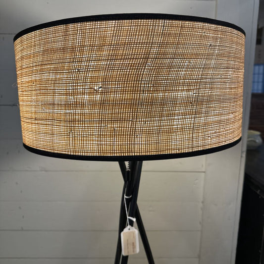 Lamp with a textured shade against a white wall