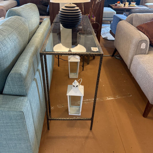 Furniture store setting with a glass table and chairs on a brown floor.