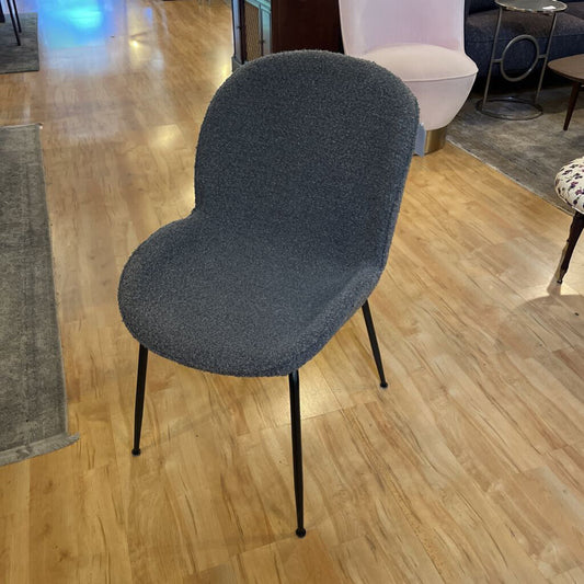 Gray chair on a wooden floor in an indoor setting