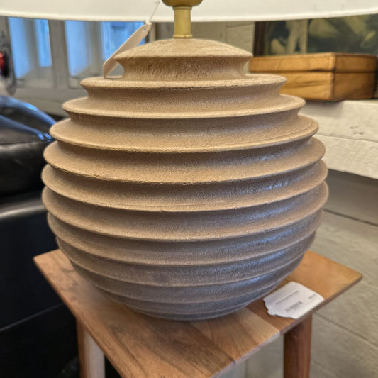 Textured ceramic vase on a wooden surface with a blurred background