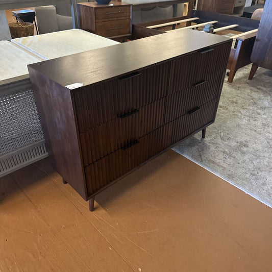 Dark wood dresser in a room with furniture and flooring.