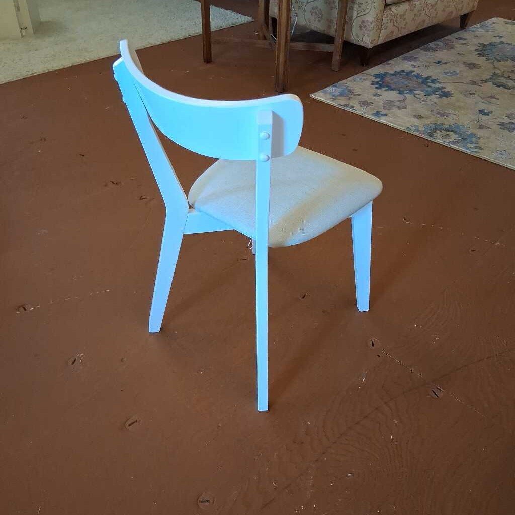 Blue chair on a brown floor with a patterned rug in the background