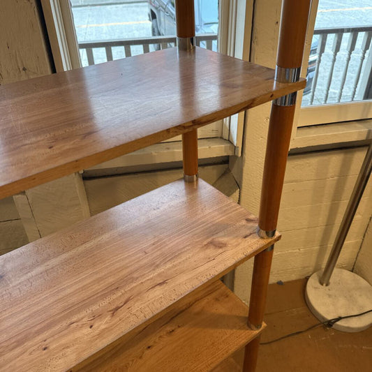 Wooden shelf with two shelves in a room with a window in the background
