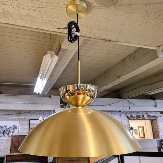 Gold pendant light hanging from a ceiling in an indoor setting