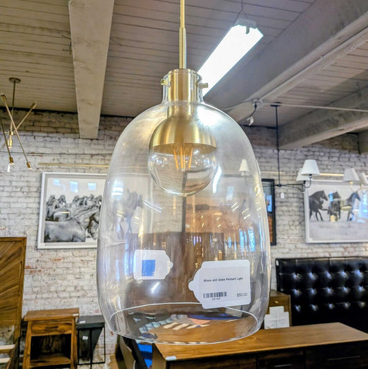 Clear glass pendant light with gold fixture in a store setting