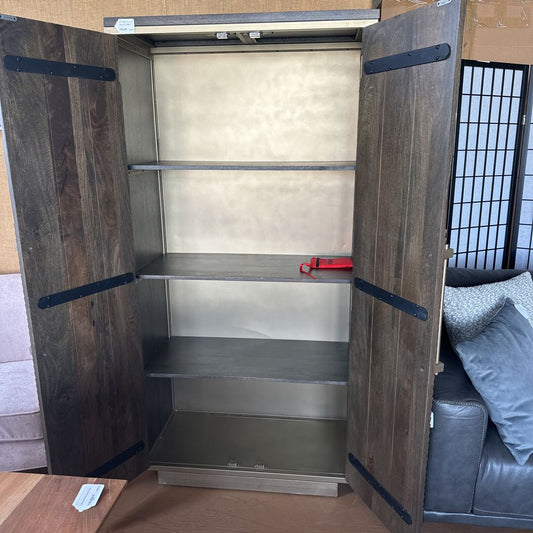 Wooden wardrobe with open doors revealing metal shelves in a room setting.