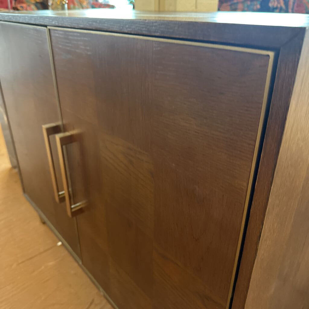 Wooden cabinet with a metallic handle on a wooden floor