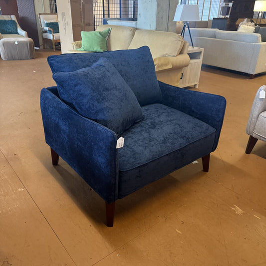 Blue upholstered chair with cushions in a showroom setting