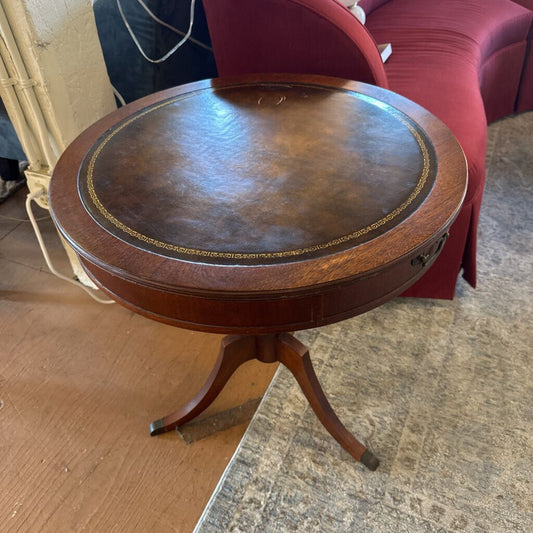 Round wooden table with leather top in a room setting