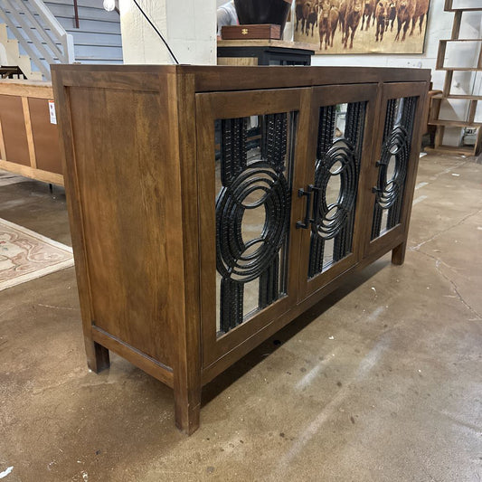Wooden sideboard with decorative metal panels in a room setting