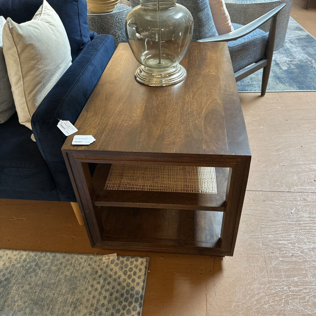 Wooden side table with a glass lamp in a living room setting