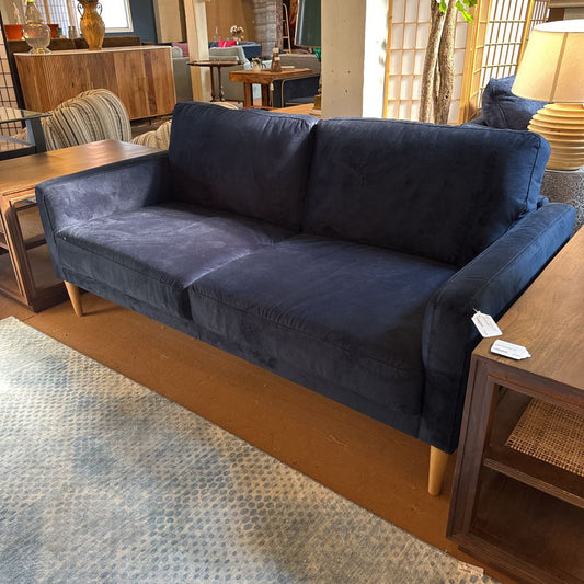 Blue sofa in a room with wooden furniture and decor