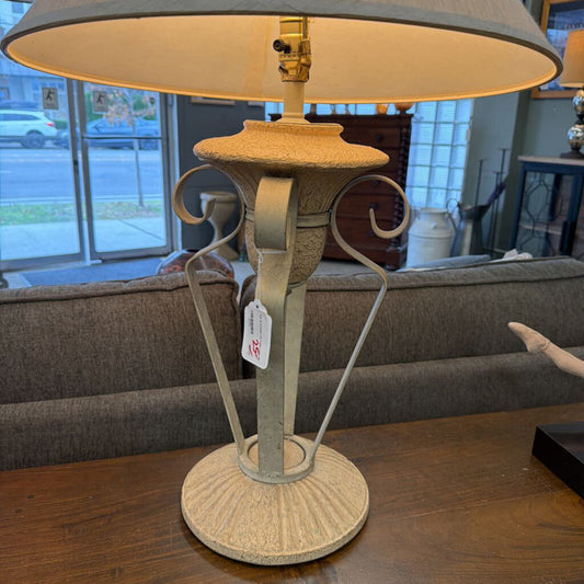 Decorative table lamp with a beige base and gray shade on a wooden surface.