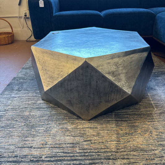 Geometric coffee table with a blue top and gray base in a living room setting.
