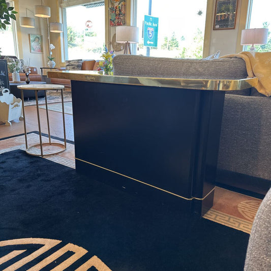 Modern interior design with a dark blue reception desk and gold accents.