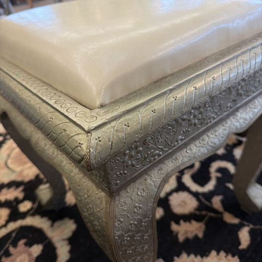 Decorative stool with intricate patterns on a patterned rug