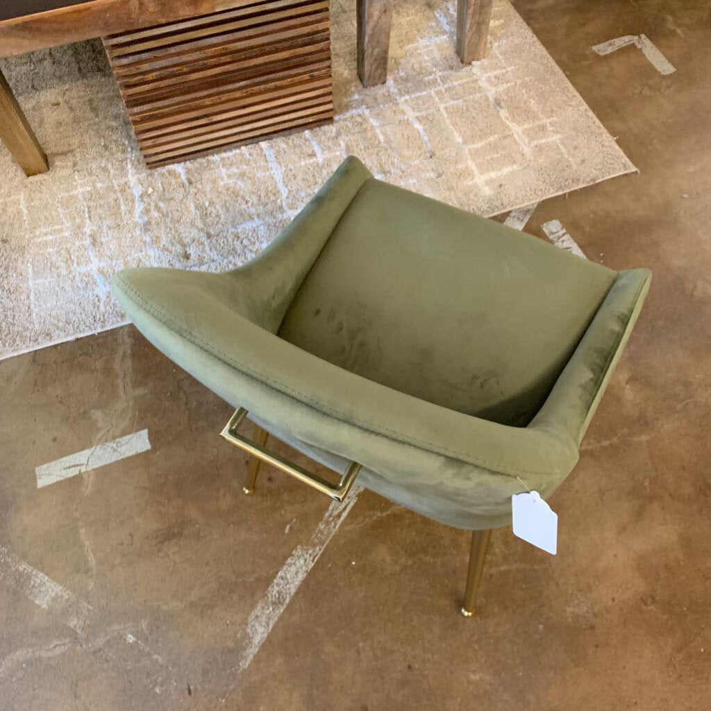 Green chair with gold legs on a tiled floor