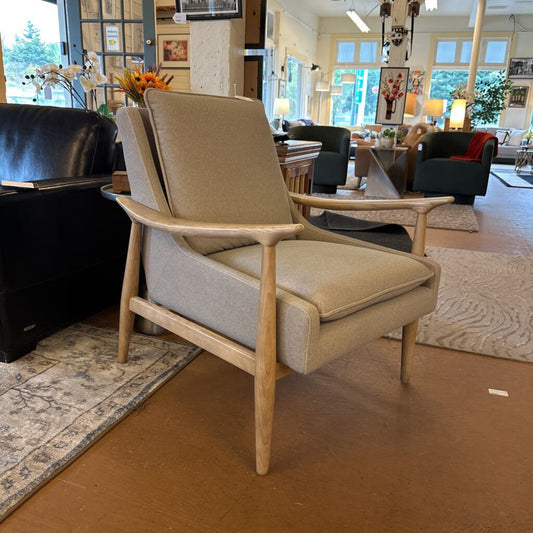 Beige armchair in a living room setting with furniture and decor.