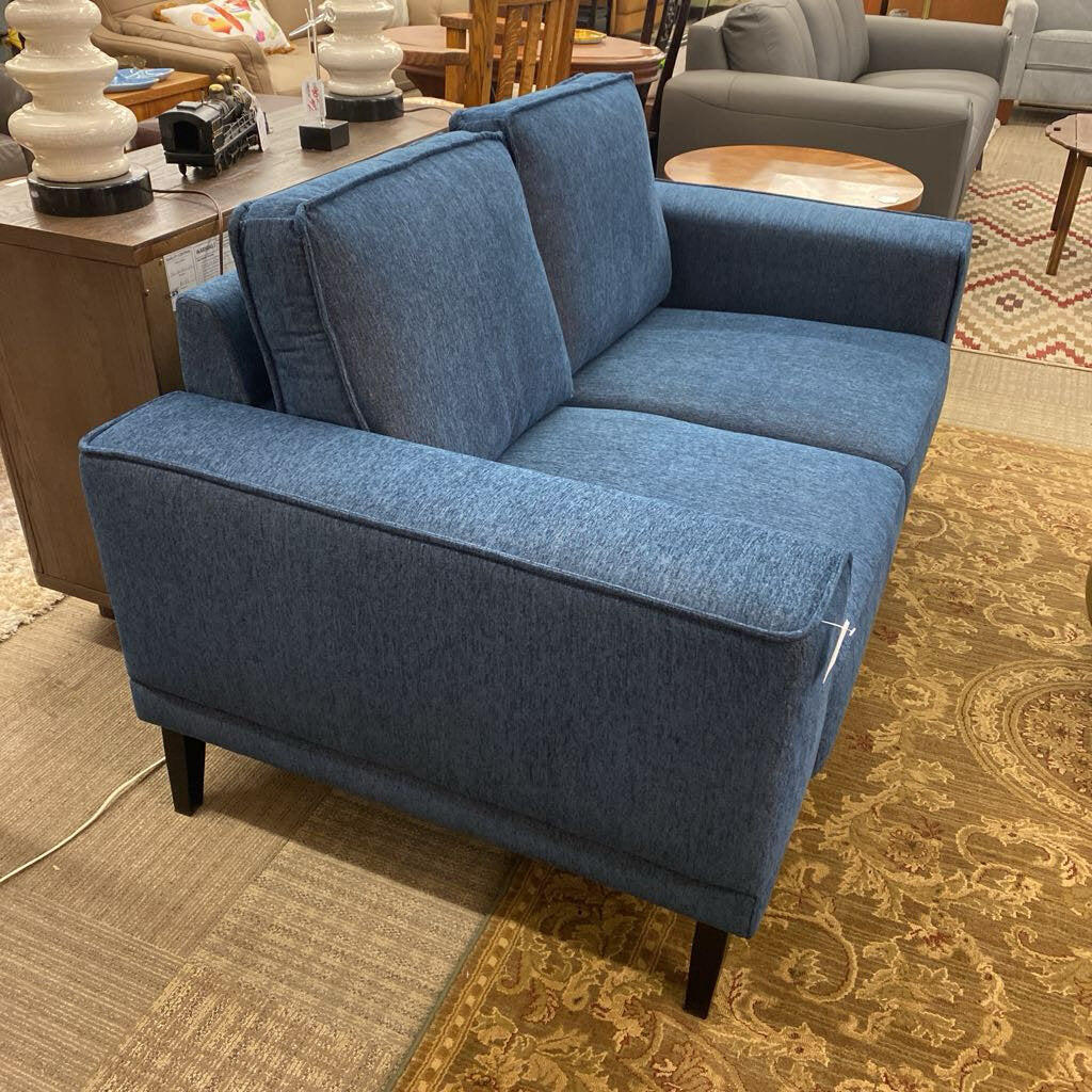 Blue sofa in a room with furniture and decor