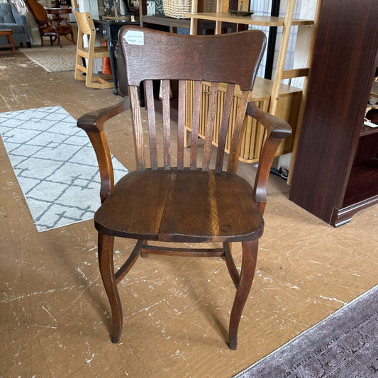 Wooden chair in a store setting with furniture and decor items in the background