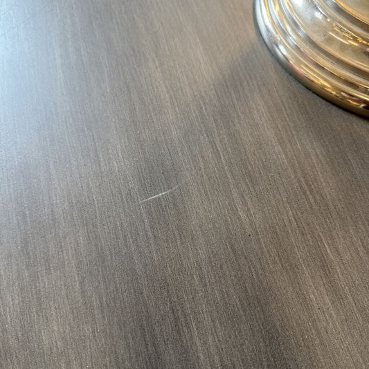 Close-up of a wooden surface with a glass object on it