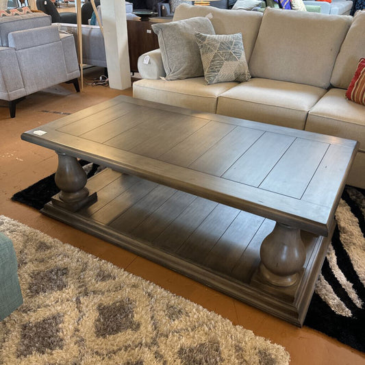 Beige sofa with decorative pillows and a wooden coffee table in a living room setting.