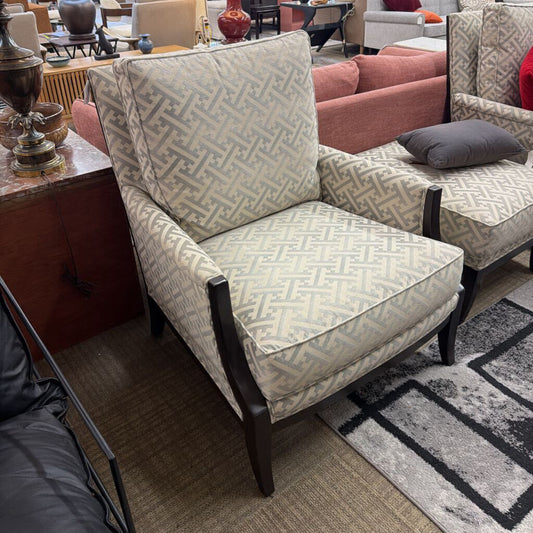 Patterned armchair in a showroom setting with other furniture.