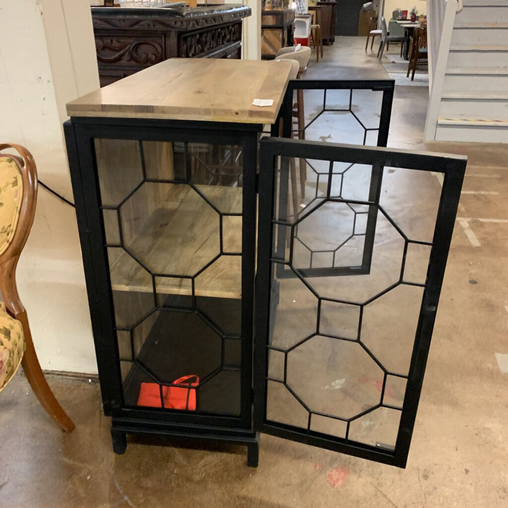 Black glass-fronted cabinet with geometric design in a store setting