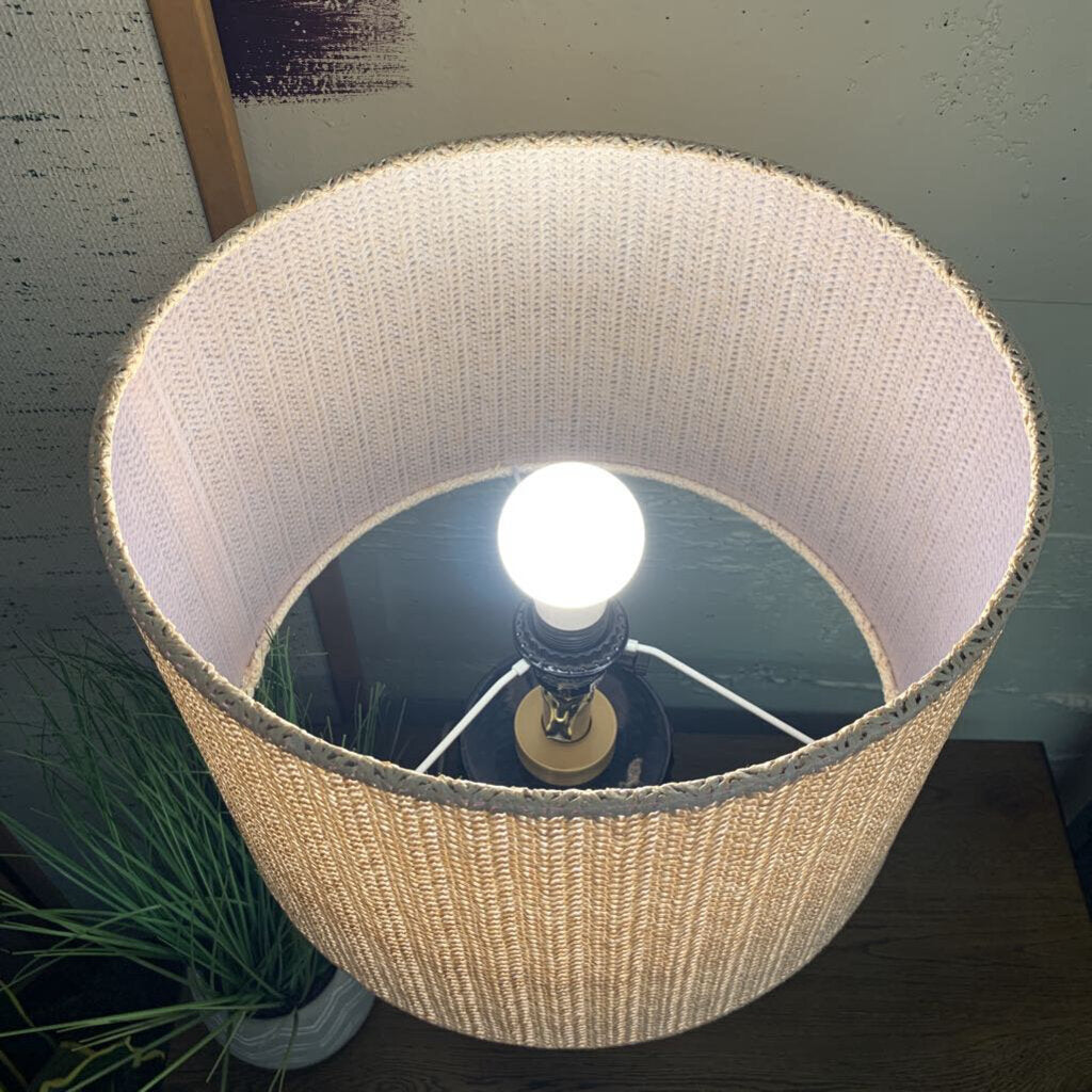 Close-up of a lamp with a white shade and visible light bulb.