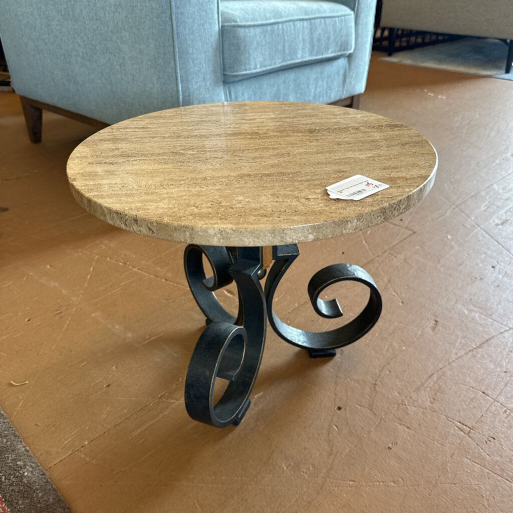 Round wooden table with metal legs on a wooden floor