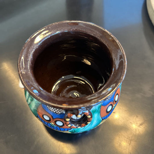 Ceramic cup with colorful patterns on a metallic surface